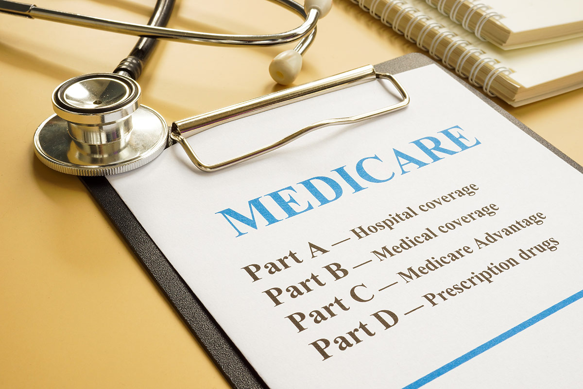 HedgeGuard Senior Benefits Medicare information booklet opened to a page listing parts a-d with a stethoscope on top, placed on a yellow background by Senior Insurance Services.